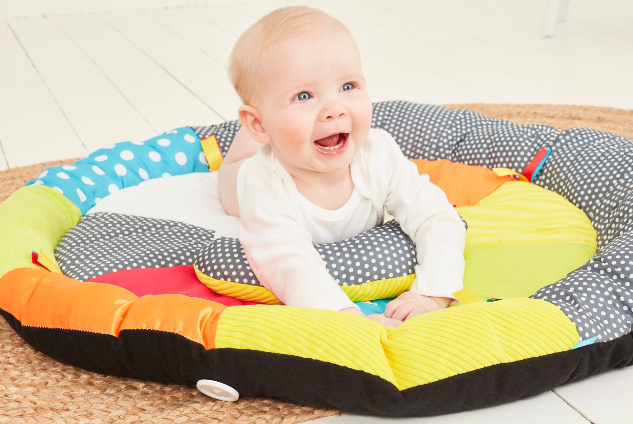 Baby enjoying tummy time on an Early Learning Centre play mat