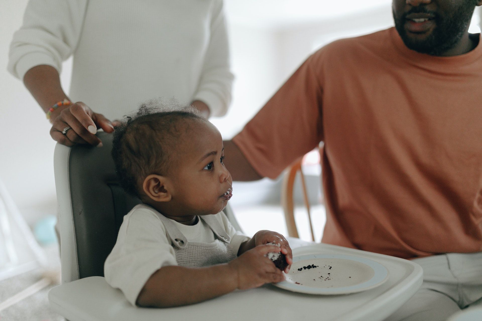 Baby tries eating food.