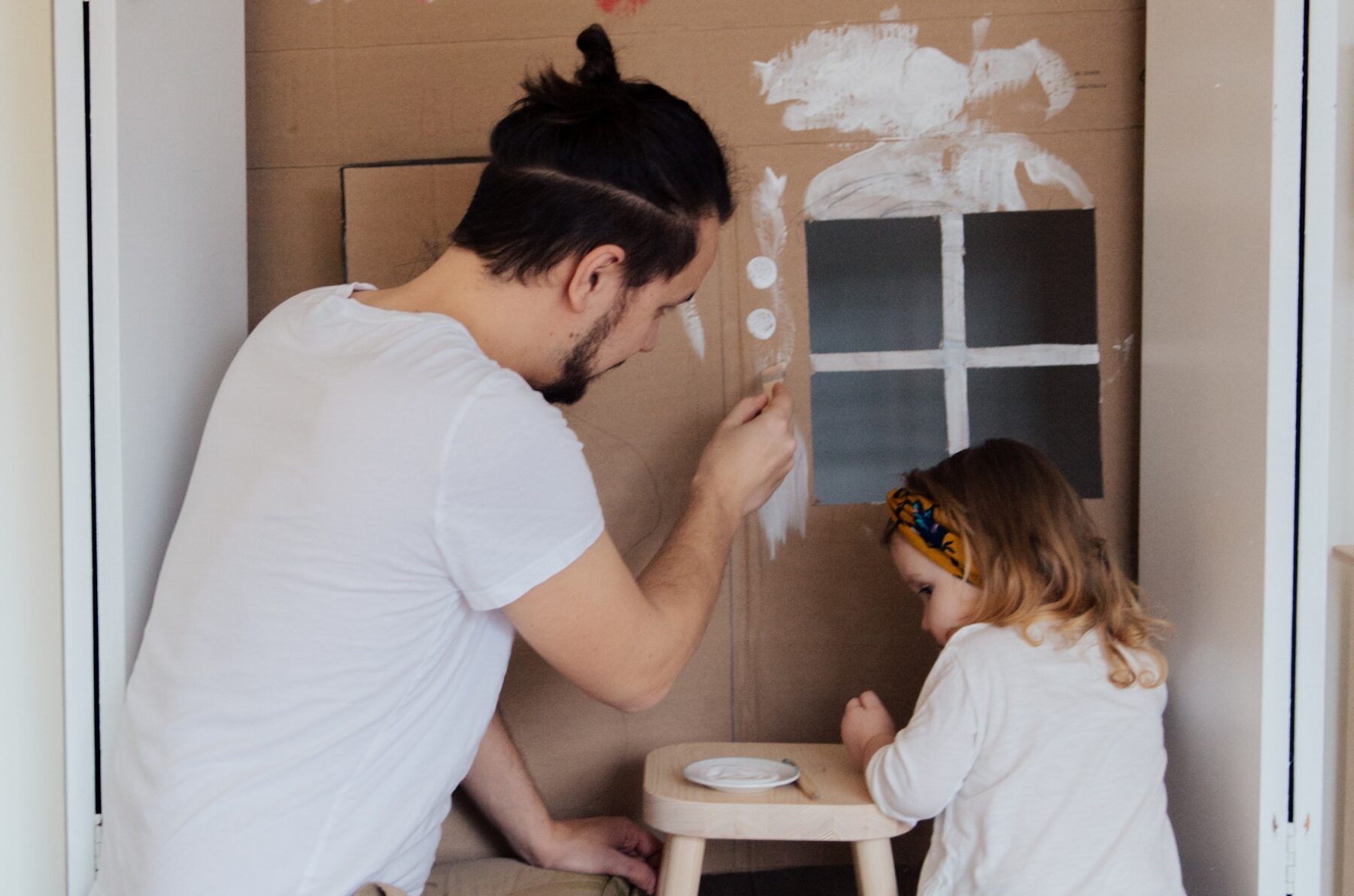 Dad paints with daughter.