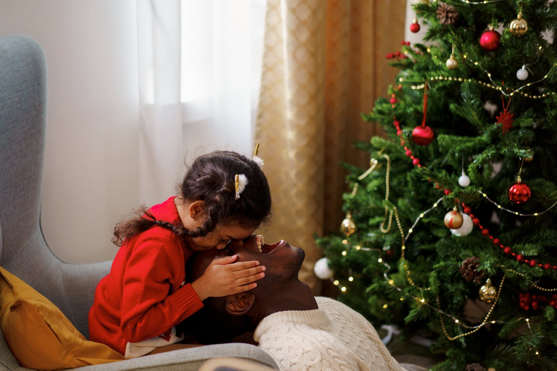 Father and daughter sat by tree.