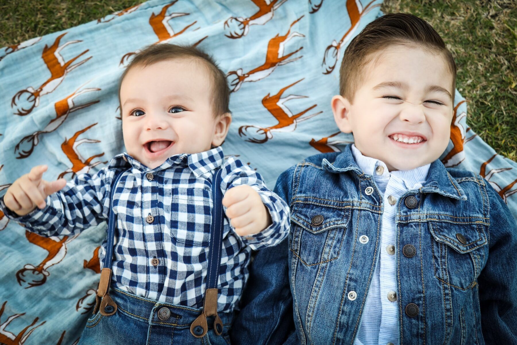 A baby and boy on a blanket