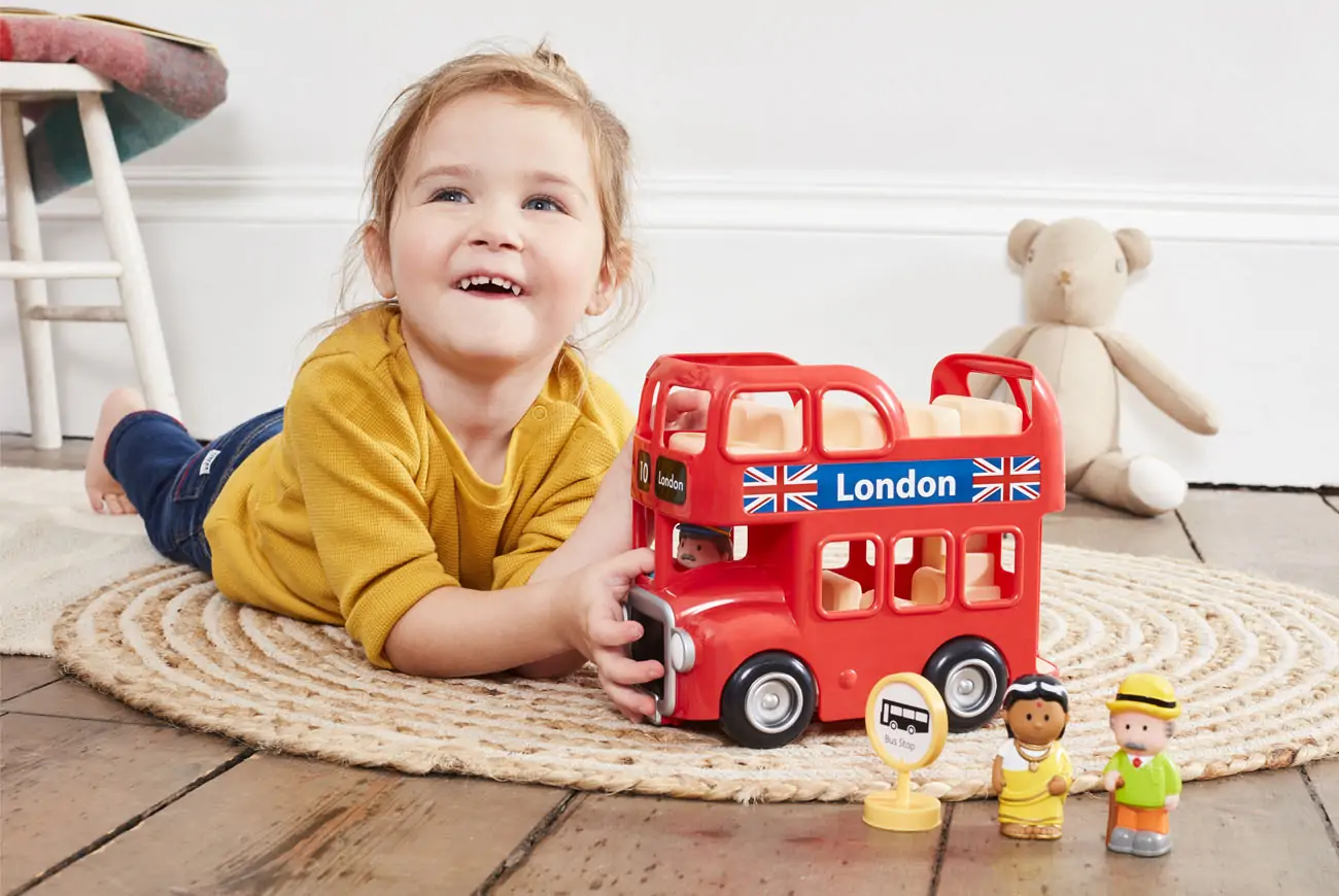 Girl playing happily with Early Learning Centre Bus