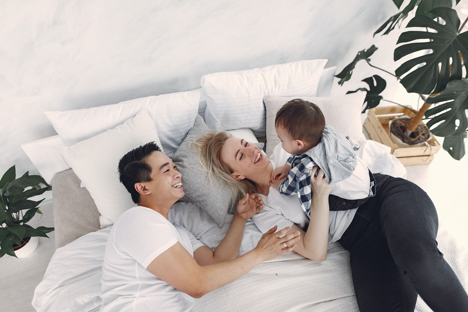 Family laying on bed playing with baby.