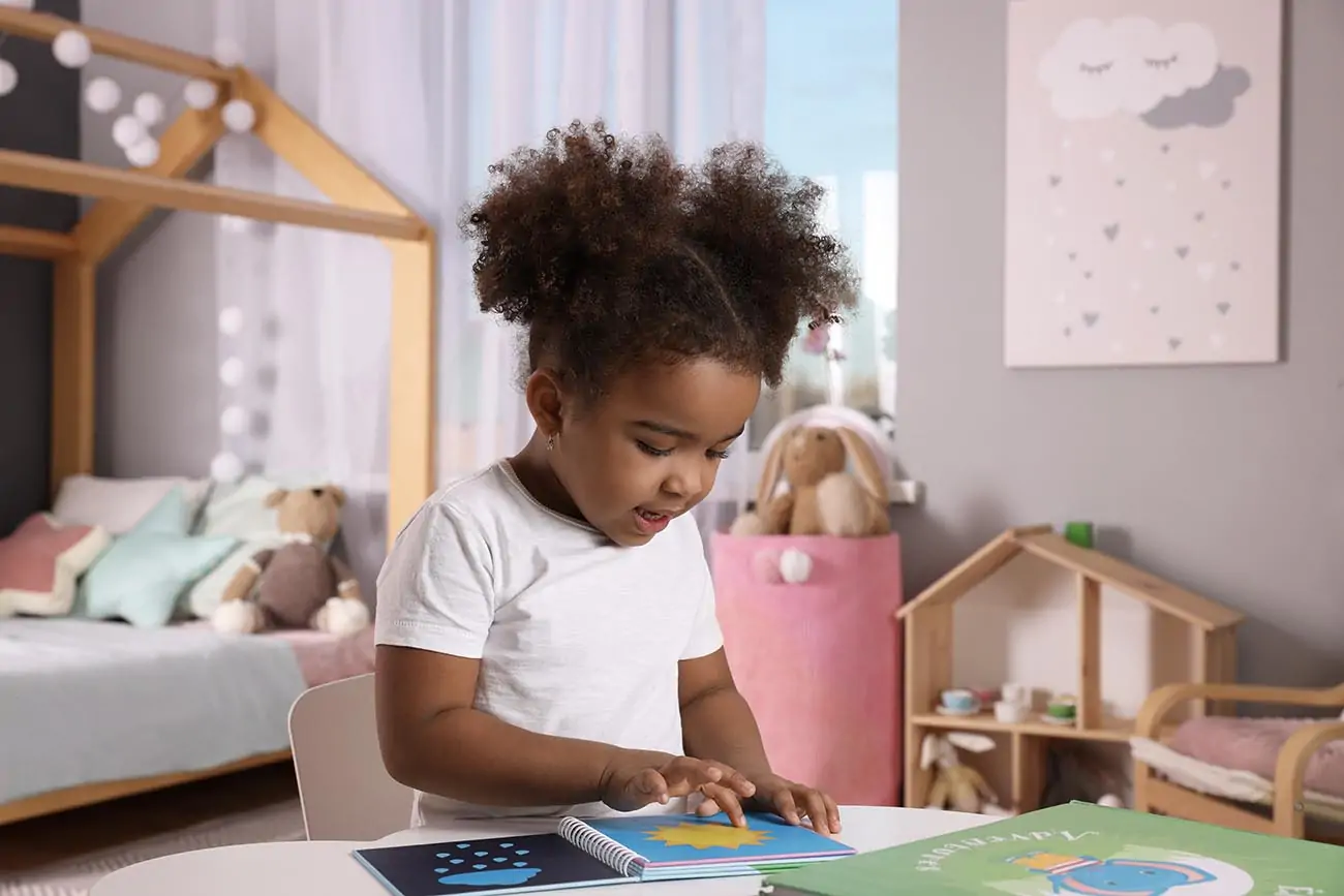 Toddler sat at desk learning.