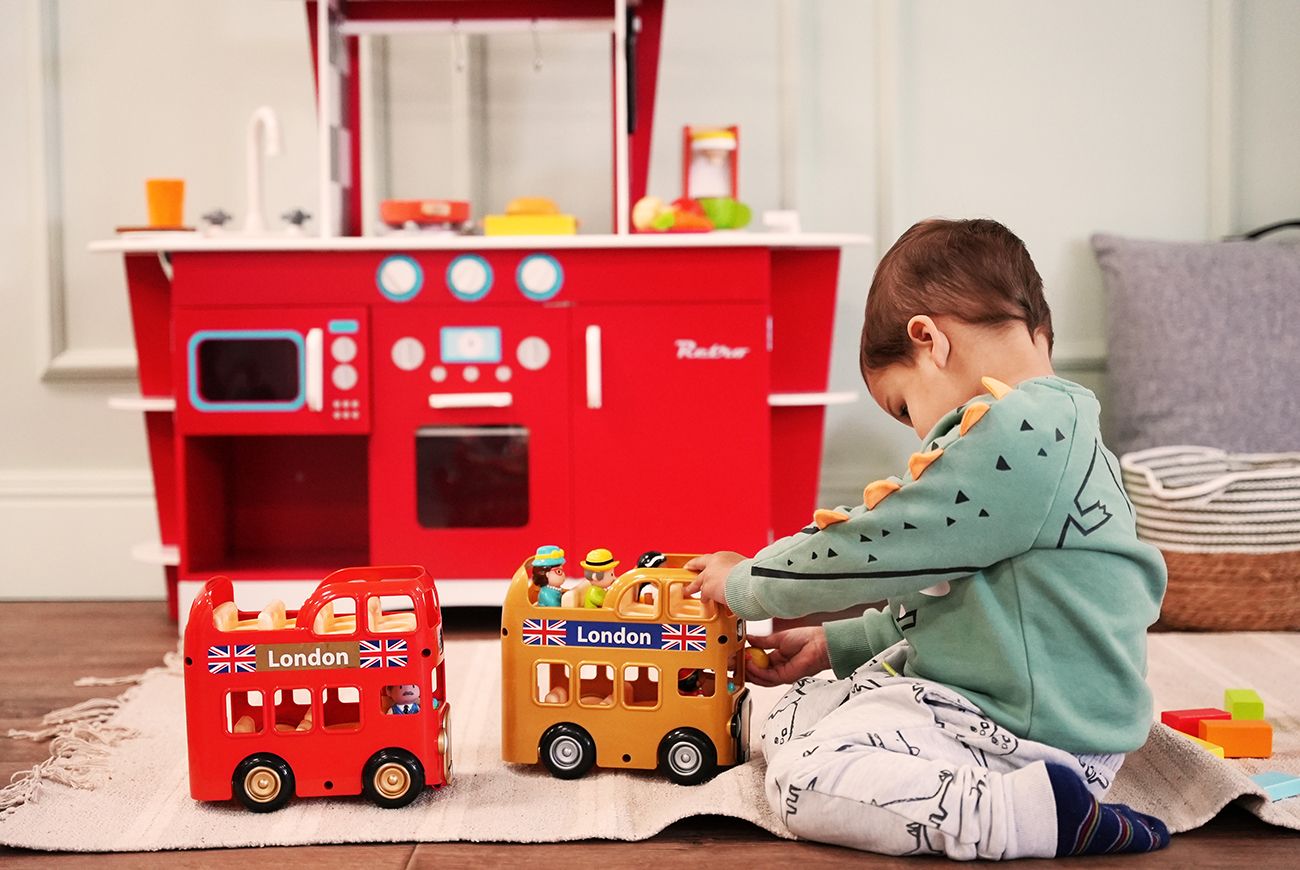 Small child playing with toy buses