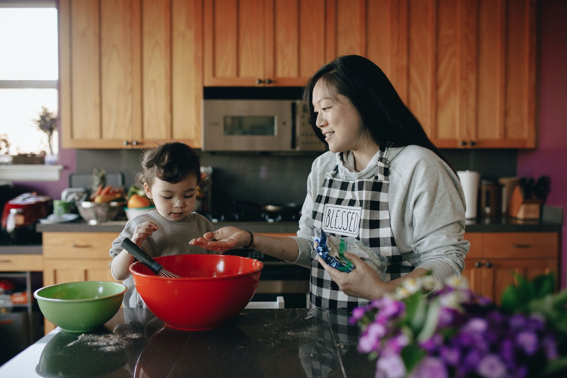 Mum in kitchen with toddler baking.