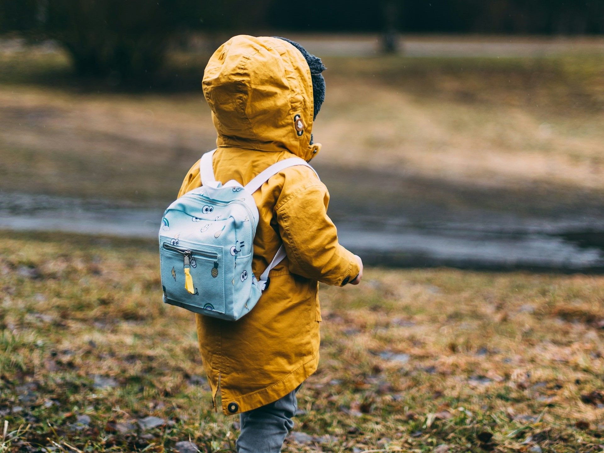 Child walking with backpack on.