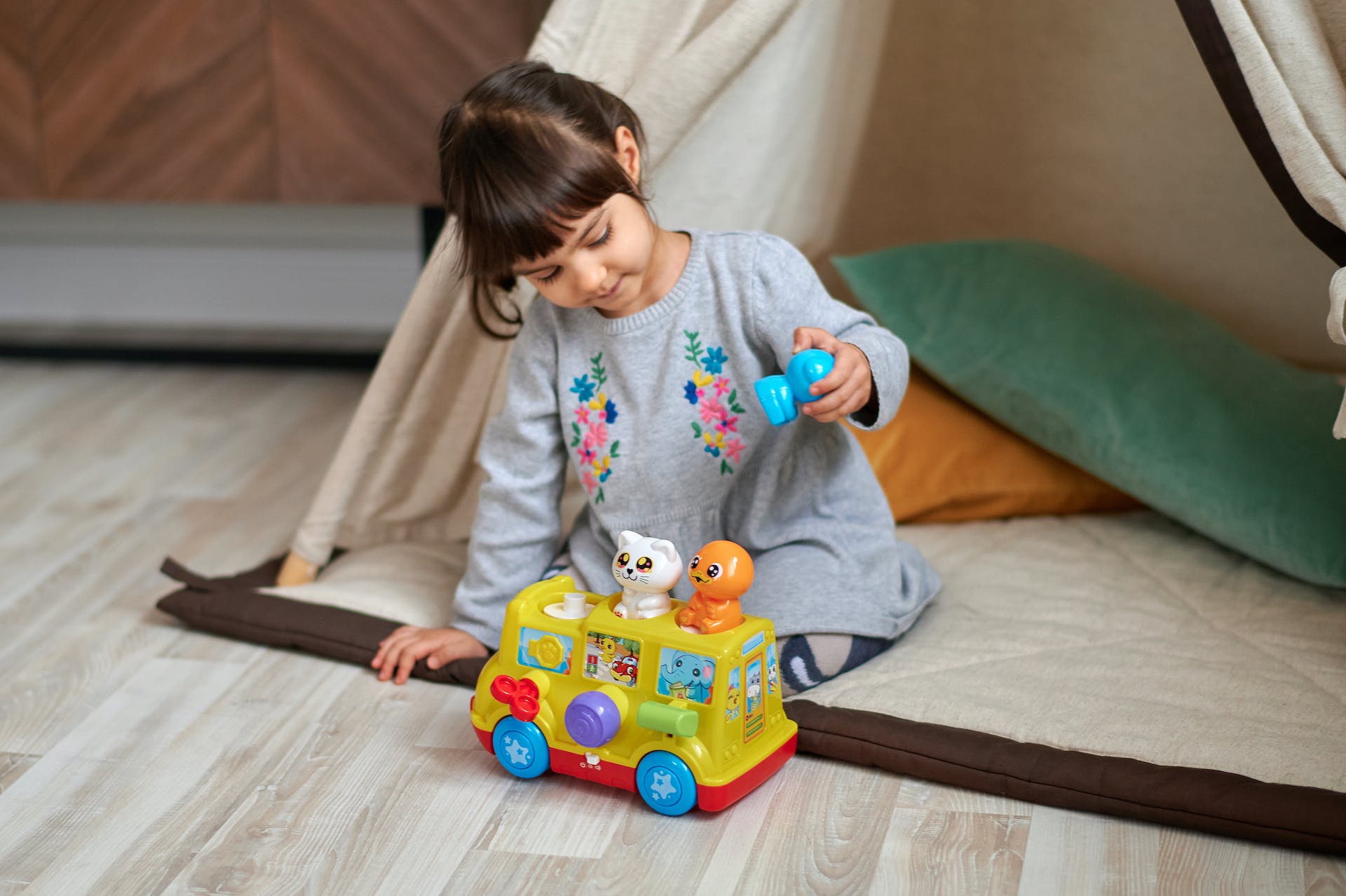 Girl plays with doll.