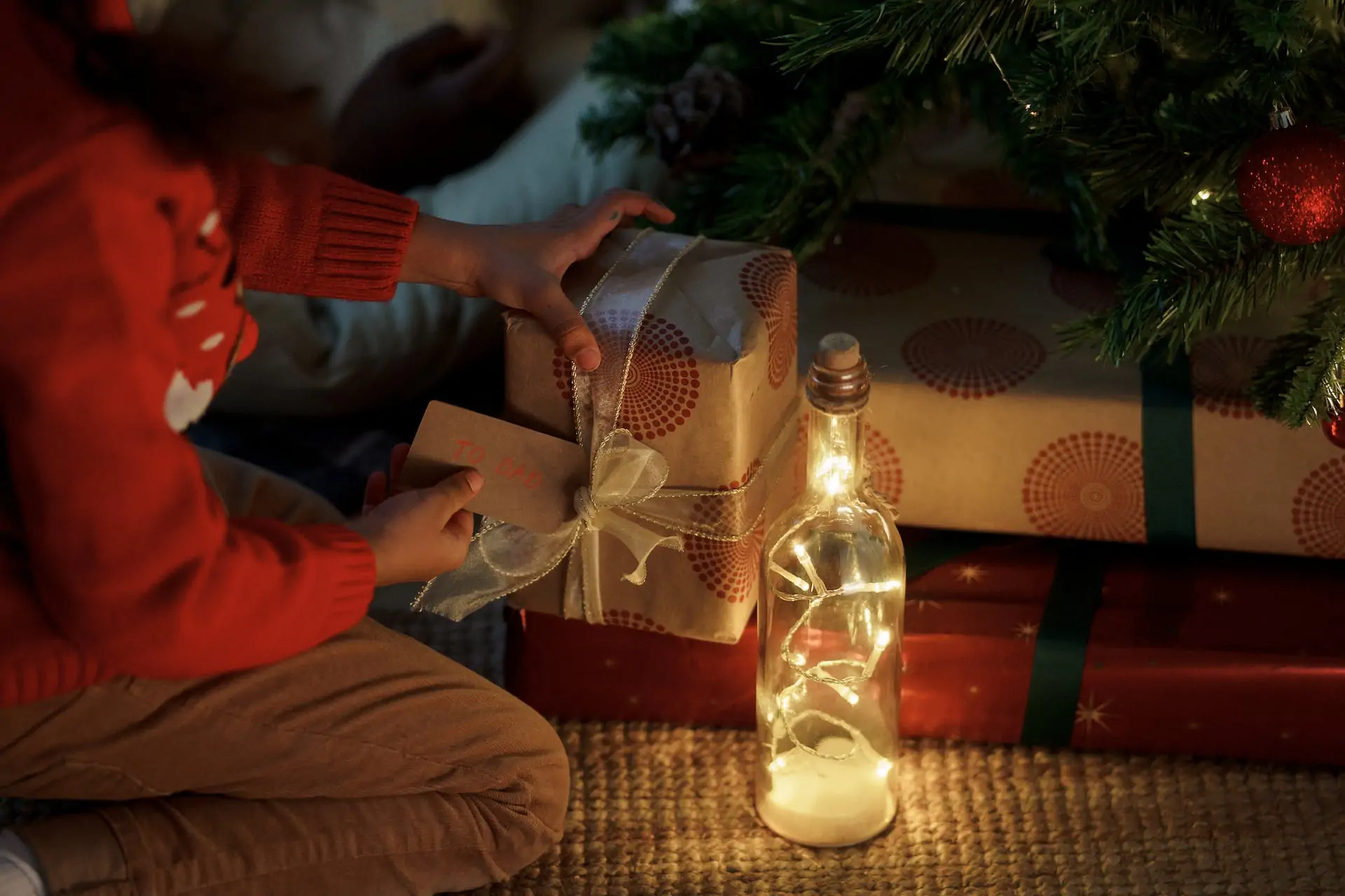 Child placing present under tree.