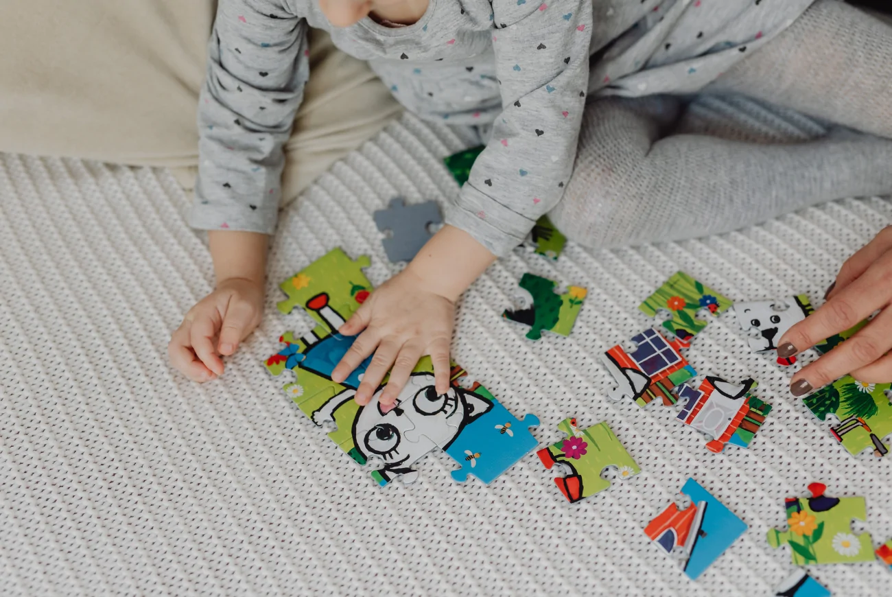 Child plays with wooden puzzles.