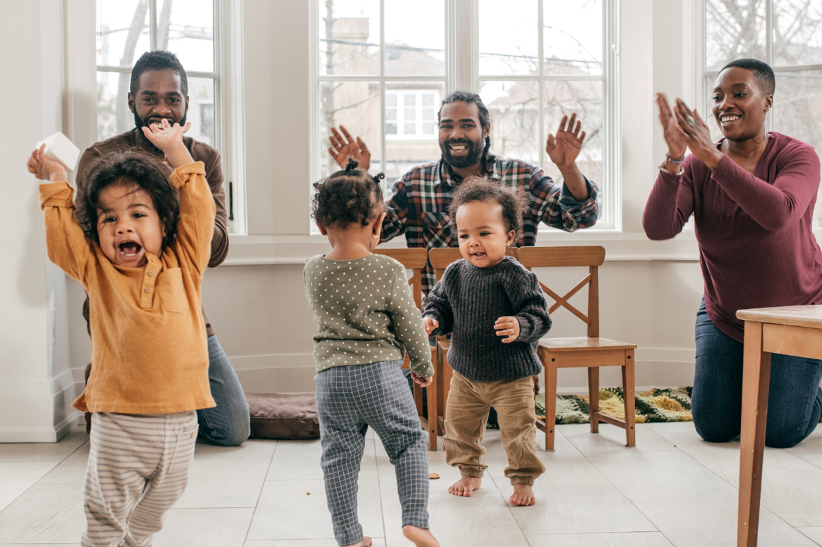 Kids play and dance around with parents in the back.