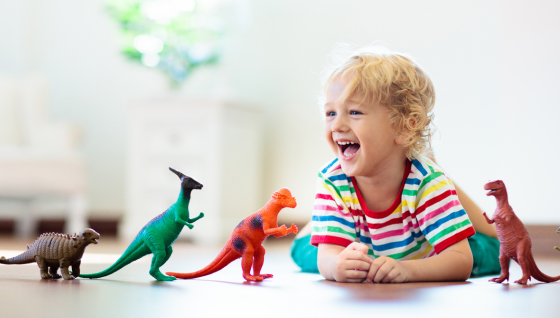 Boy playing with dinosaur toys