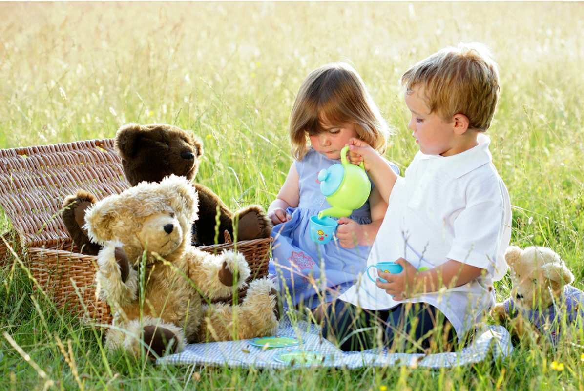 Two toddlers play at a picnic.